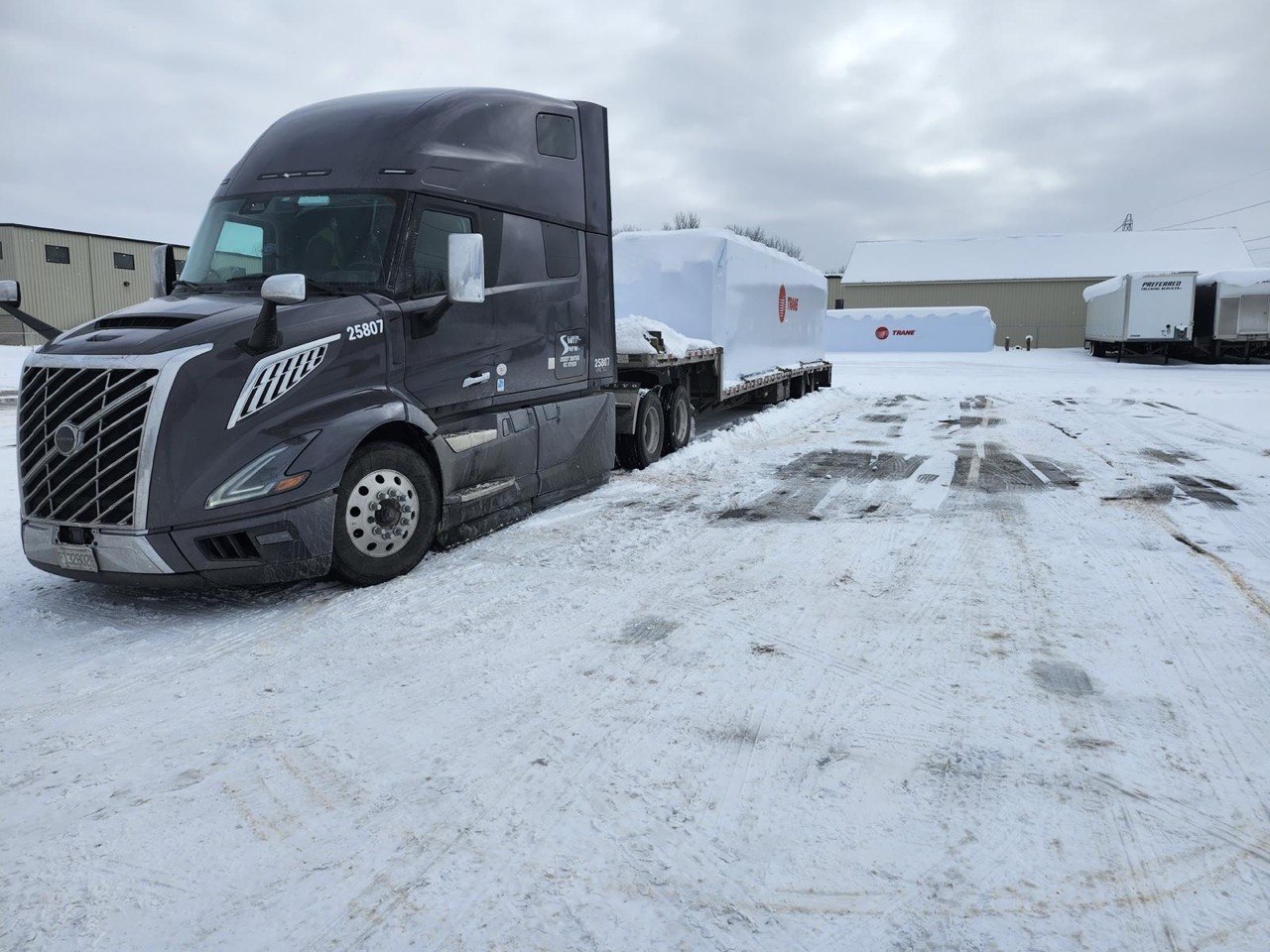 Volvo VNL flatbed carrying industrial HVAC cargo