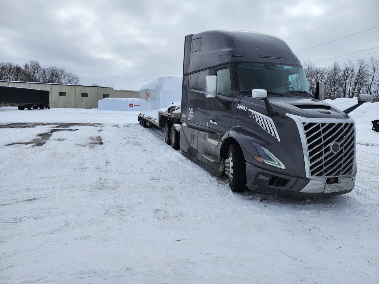 Volvo VNL carrying flatbed cargo in winter conditions