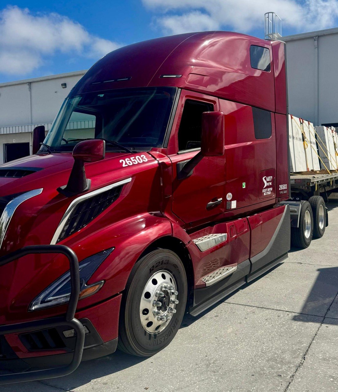 Red Volvo VNL with structural flatbed load
